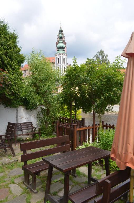a table and benches with a building in the background at Guest House Olšakovský in Český Krumlov
