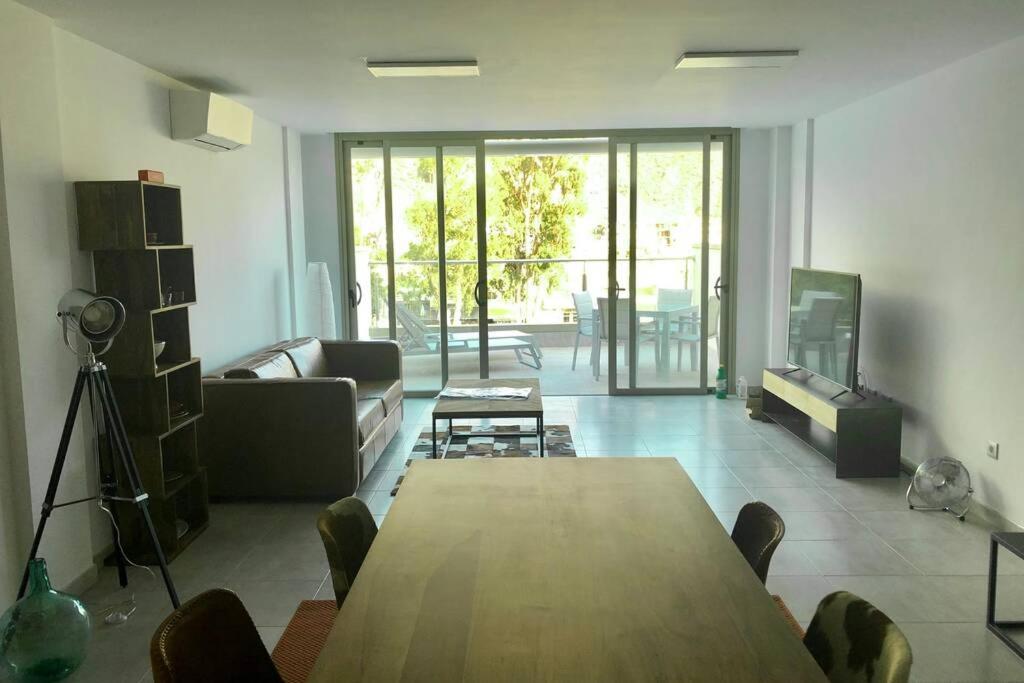 a living room with a wooden table and a couch at SUN, SEA AND ROCKS in Puerto de Mogán