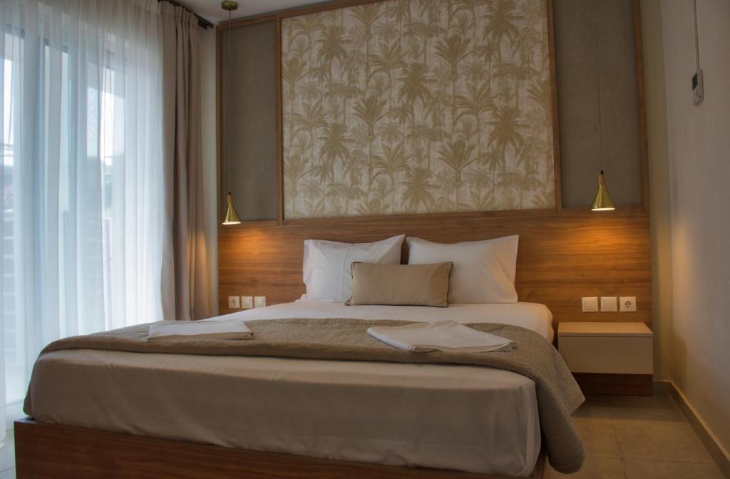 a bedroom with a large bed with a painting on the wall at Astra Sarti Luxury Suites in Sarti