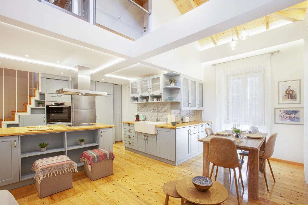 a kitchen with white cabinets and a table with chairs at The Dreamy Loft Corfu in Corfu Town