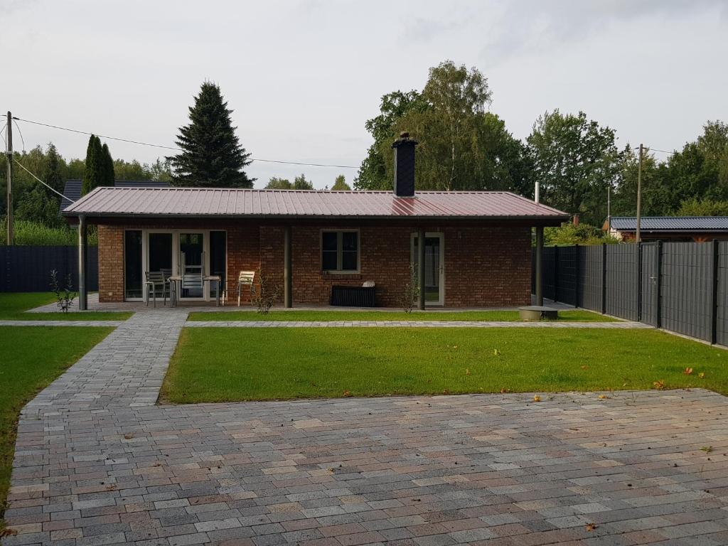 una piccola casa in mattoni con un vialetto in mattoni di Bungalow am Neustädter See a Neustadt-Glewe