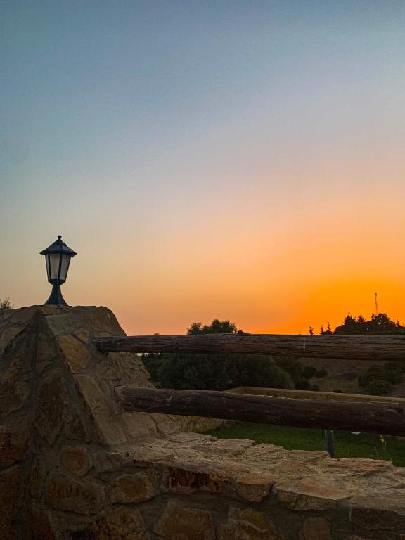 a street light on top of a stone wall at sunset at Dmina House in Asilah