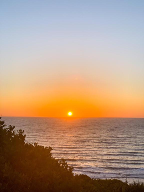 a sunset over the ocean with the sun setting at Dmina House in Asilah