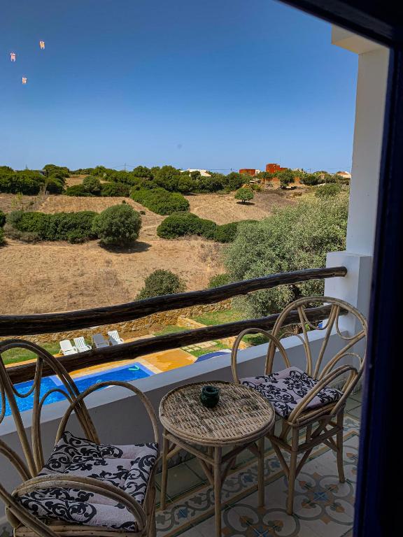 a balcony with two chairs and a table with a view at Dmina House in Asilah