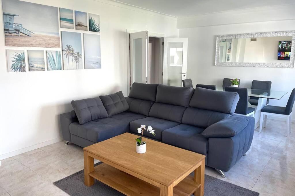 a living room with a blue couch and a coffee table at Apartamento Feliz in Figueira da Foz