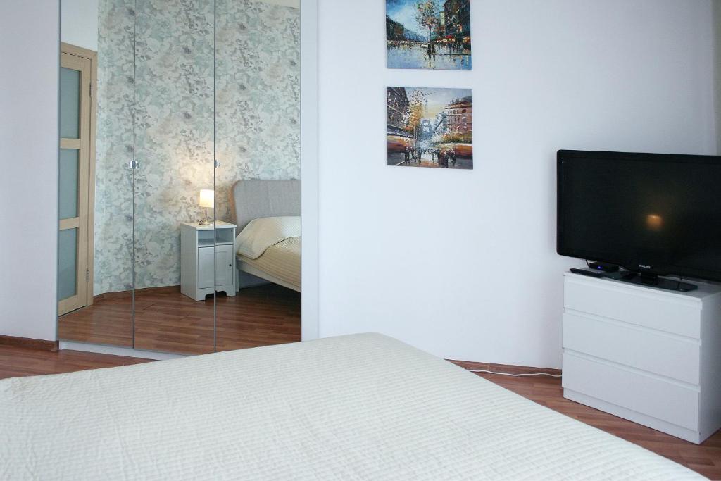 een slaapkamer met een bed en een flatscreen-tv bij Аквамарин мини отель на Радищева 18 in Jekaterinaburg