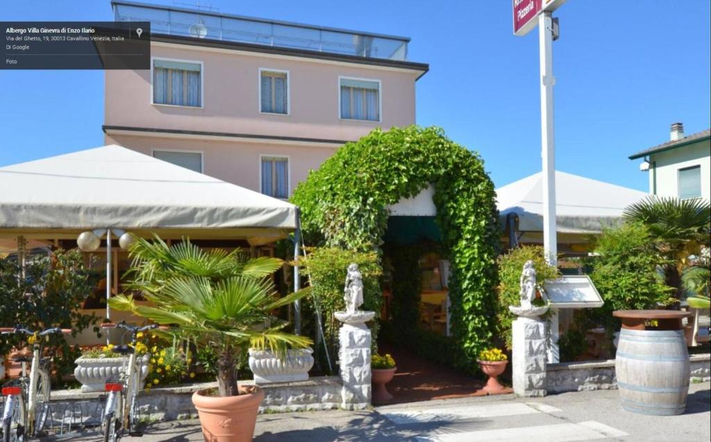 un edificio con un arco y plantas delante de él en Hotel Villa Ginevra, en Cavallino-Treporti