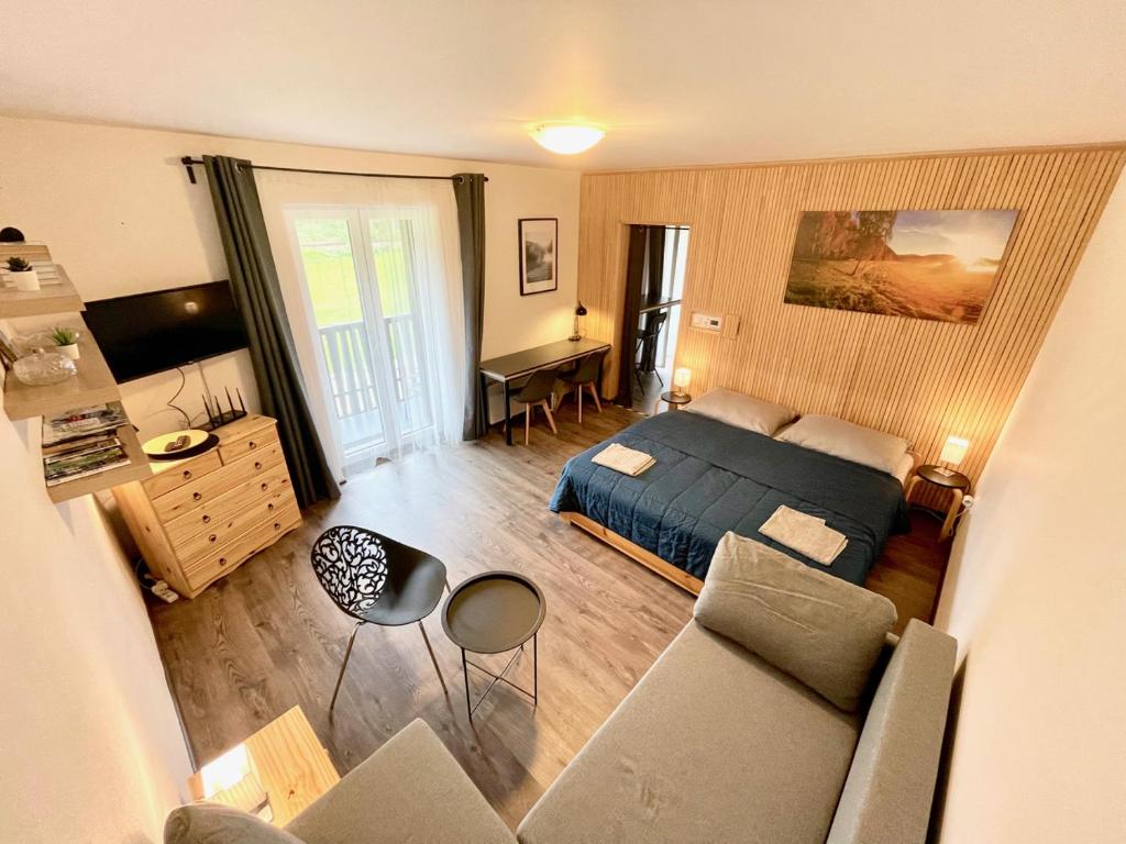a bedroom with a bed and a living room at Apartmán u jezera Lipno - Nové in Nová Pec