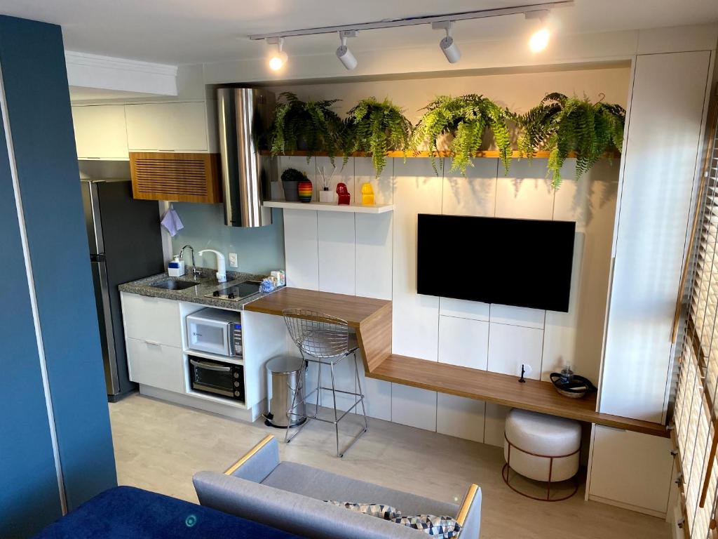 een kleine keuken met een flatscreen-tv in een kamer bij Is Liberdade 13 in Sao Paulo