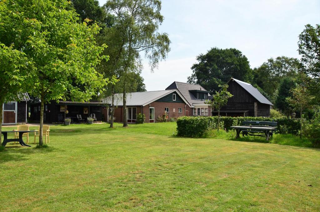 park z budynkiem i ławką w trawie w obiekcie Wagenschuur w mieście Emst