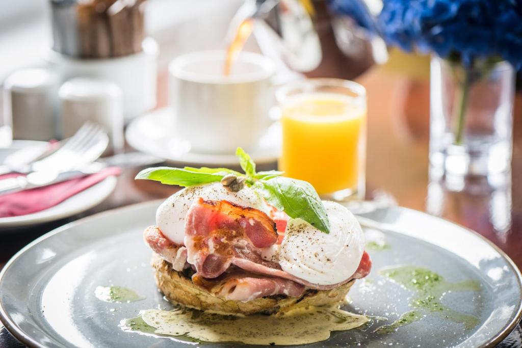 a sandwich on a plate on a table with a glass of orange juice at Gabriel House Guesthouse in Cork