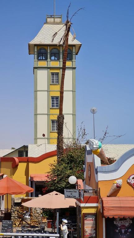een gebouw met een klokkentoren op de achtergrond bij Bismarck Swakopmund in Swakopmund