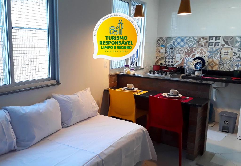 Cette chambre comprend un lit, une table et une cuisine. dans l'établissement Hart Aparthotel Ltda, à Salvador