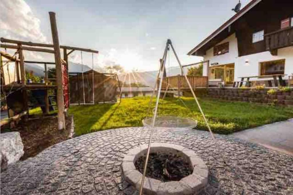 a stone patio with a fire pit in a yard at Beautiful cosy House near Königsee in Schönau am Königssee