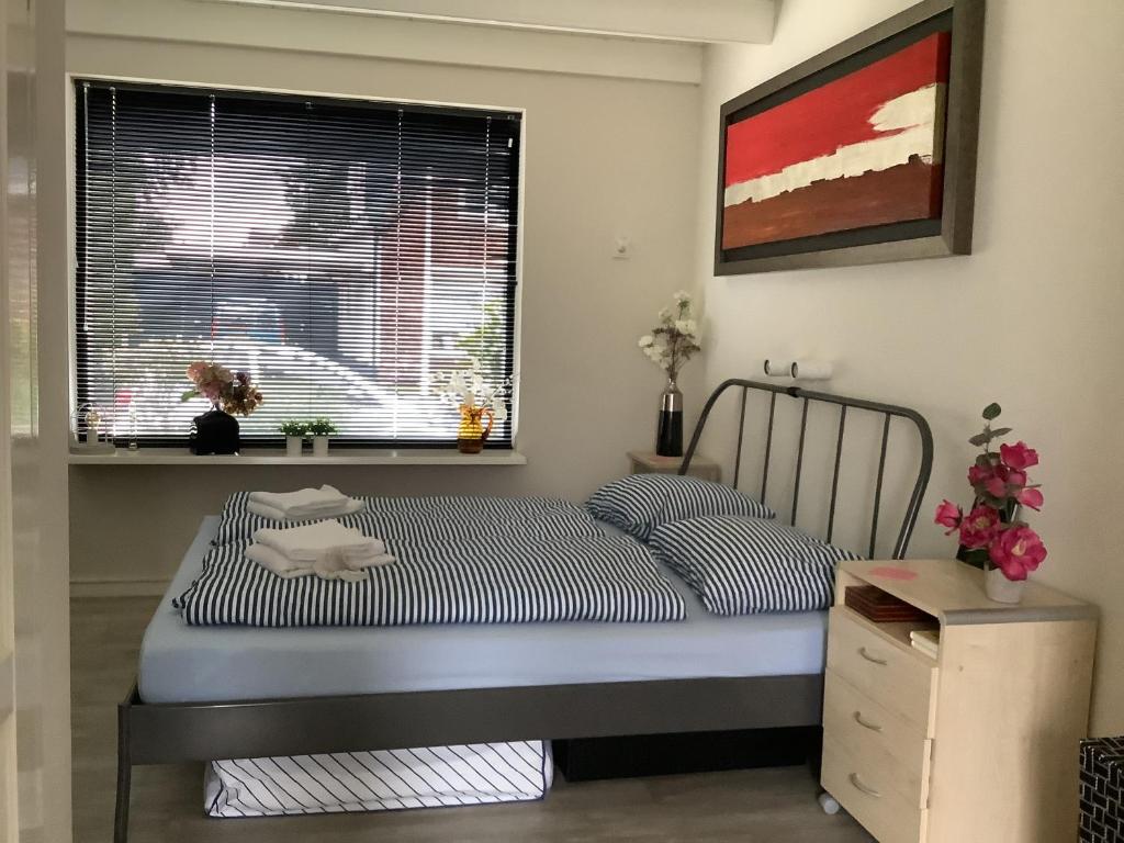 een kleine slaapkamer met een bed en een raam bij 2 persoons appartement de luxe in Nijverdal