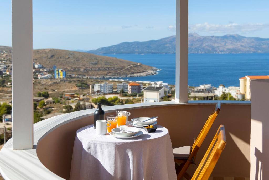 a table with a plate of food on a balcony at Casa Noste Apartments in Sarandë