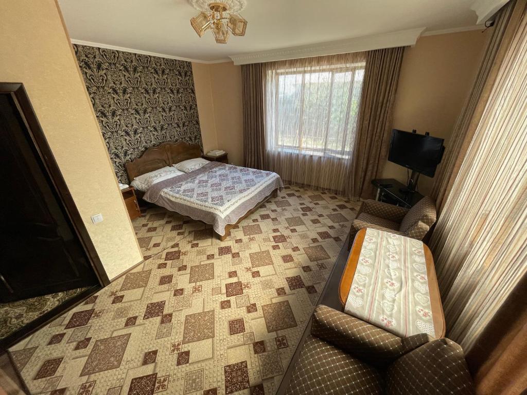 uma sala de estar com uma cama e um sofá em Guest House Eles em Karakol