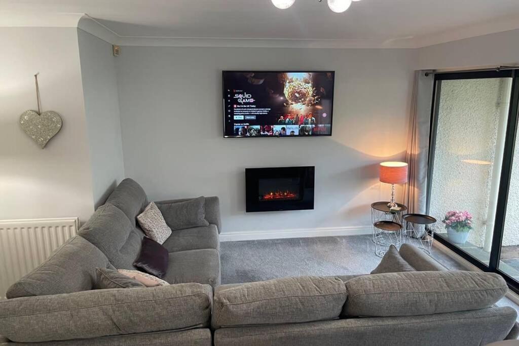 a living room with a couch and a tv on the wall at 2 bedroom 2 bathroom luxury apartment 1 minute from Lake pet friendly free parking in Winster