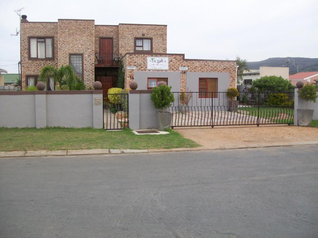 a house with a fence in front of a street at Tirzah's B&B and Self Catering in Bredasdorp