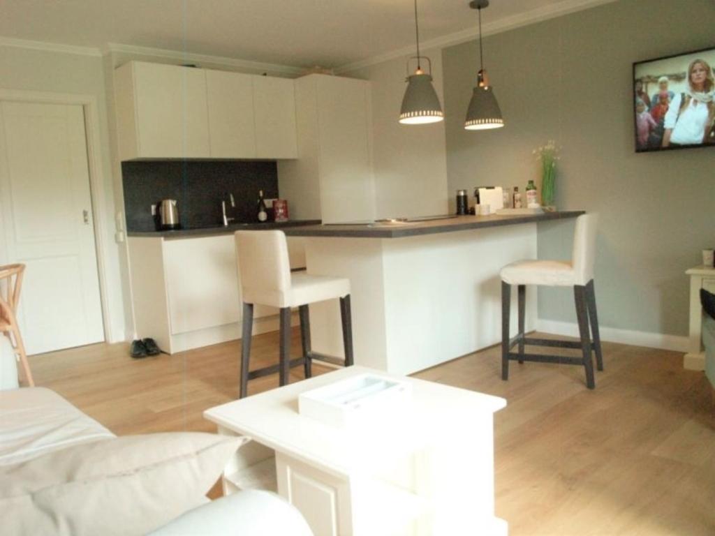 a living room with a kitchen with a table and chairs at Deichblick - a26817 in Büsumer Deichhausen