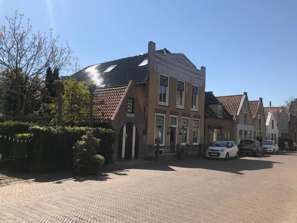 um edifício com um carro estacionado em frente em B&B Logeren bij de burgemeester em Stad aan ʼt Haringvliet