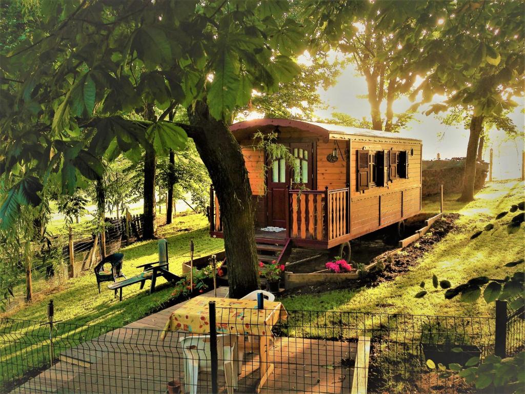 La Gypsy Caravane في Rivière: سيارة القطار تقف بجانب شجرة