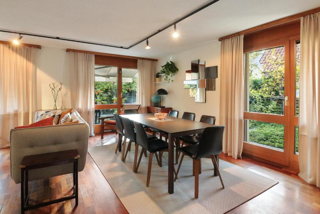 - une salle à manger avec une table et des chaises dans l'établissement Magnifique villa proche du lac de Morat, à Morat