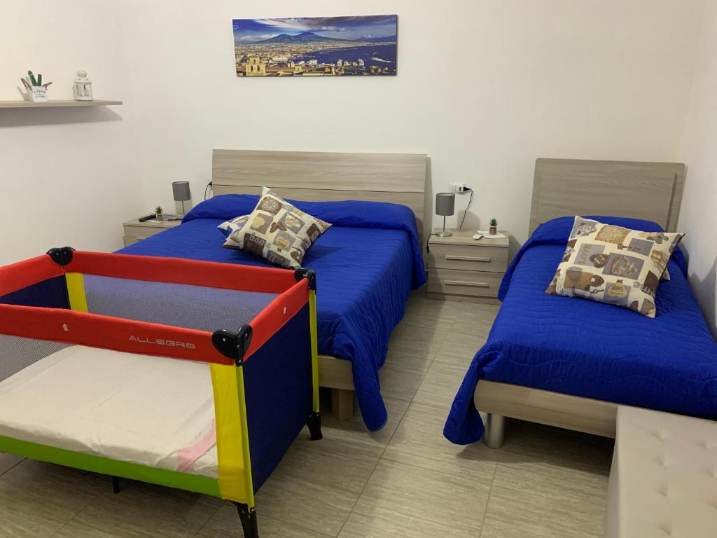 1 Schlafzimmer mit 2 Einzelbetten und blauer Bettwäsche in der Unterkunft La Strettola in Neapel