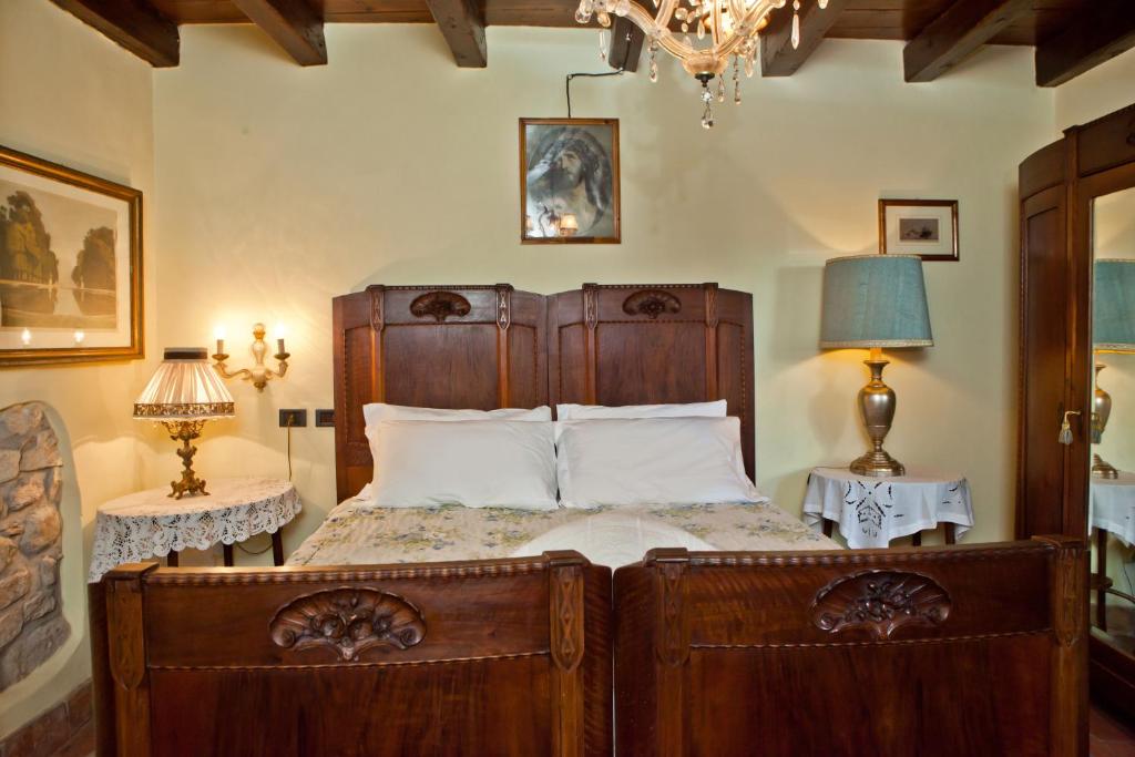 フマーネにあるAzienda Agrituristica Corteforteのベッドルーム1室(大型木製ベッド1台、ランプ2つ付)