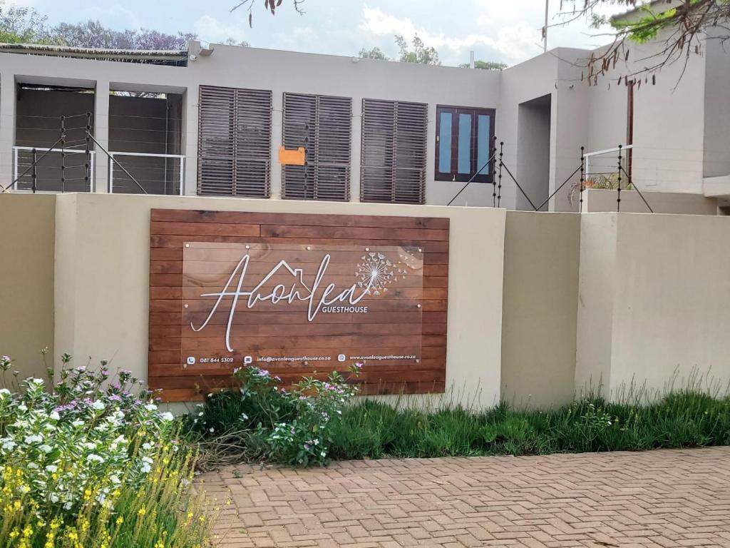 a house with a sign on a fence at Avonlea Guesthouse in Polokwane