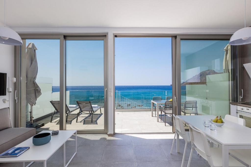 a kitchen and dining room with a view of the ocean at Aelia Seascape Apartments in Plakias