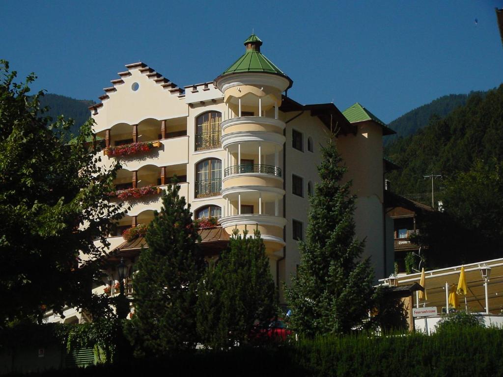 a large white building with a green roof at Hotel Sieghard Zillertal in Mayrhofen