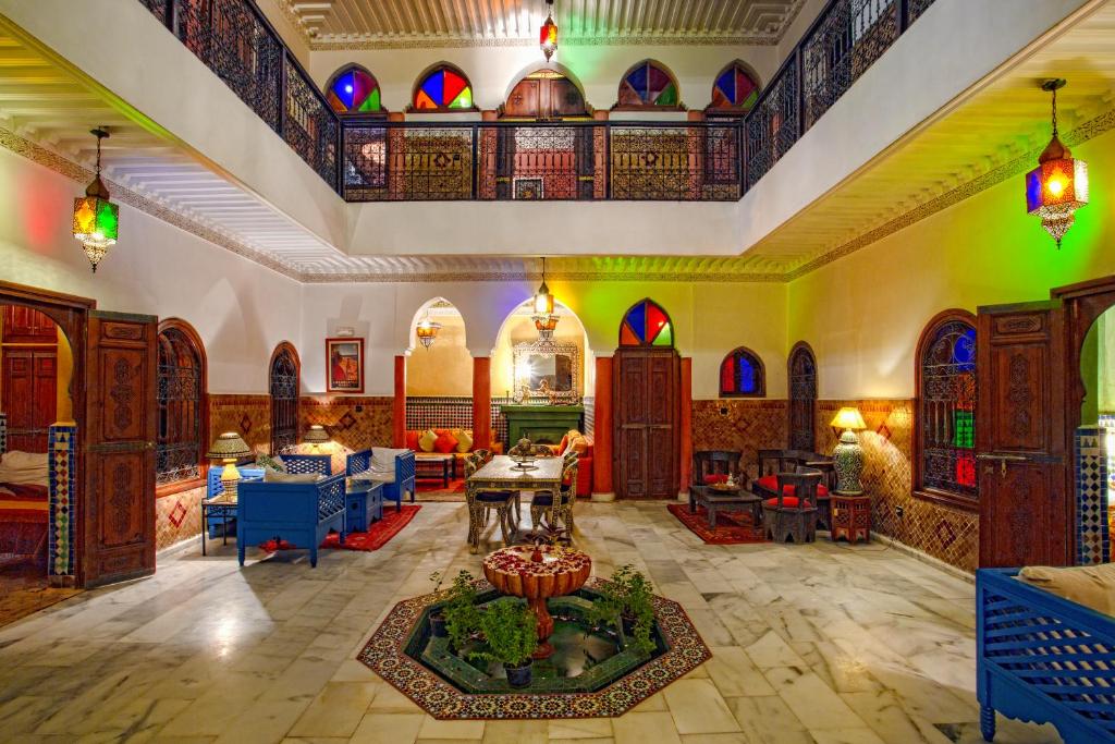 Elle comprend un salon doté d'un mobilier coloré et d'un plafond. dans l'établissement Riad Lakhdar, à Marrakech
