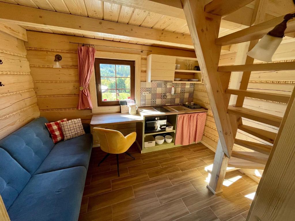 una sala de estar con un sofá azul en una cabaña en VILA Tatry Ždiar - Domček pre dvoch, en Ždiar