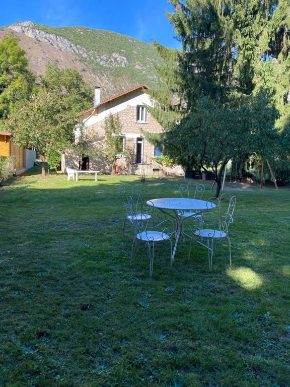 una mesa y sillas en un patio con una casa en CHALET Tout Confort Proche d AX Les Thermes en Vèbre