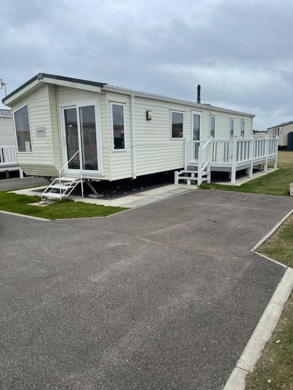 a white mobile home with a porch and a driveway at Golden Palm Chapel St Leonards 8 Berth 3 Bedroom Caravan in Skegness