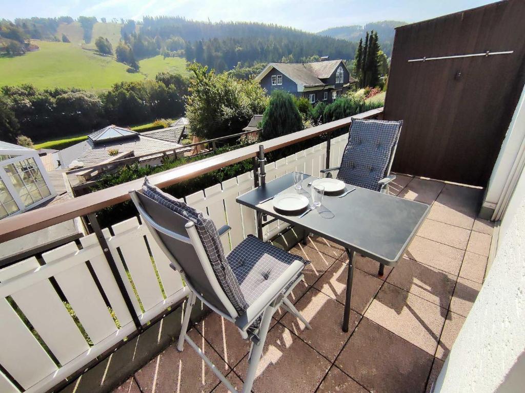 una mesa y sillas en un balcón con vistas en Ferienwohnung Marx (K1 Blick) Willingen en Willingen