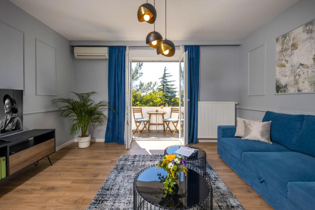 a living room with a blue couch and a table at Blue Allure Apartment in Rijeka