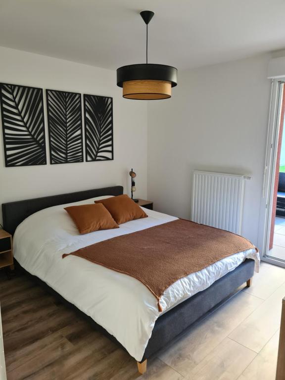 a bedroom with a large bed and a pendant light at L'instant Léman - T2 3 étoiles à 5min de Thonon et Evian avec terrasse et jardin à 100m du lac in Publier