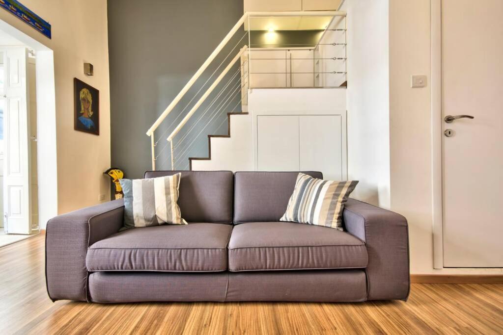 een bank in een woonkamer met een trap bij Valletta Timeless Elegance : City Centre Apartment in Valletta