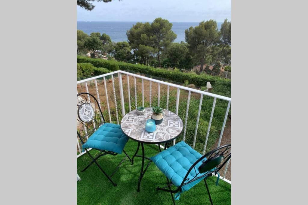balkon ze stołem i krzesłami oraz oceanem w obiekcie STUDIO VUE MER /PARKING PRIVATIF w miejscowości Saint-Raphaël