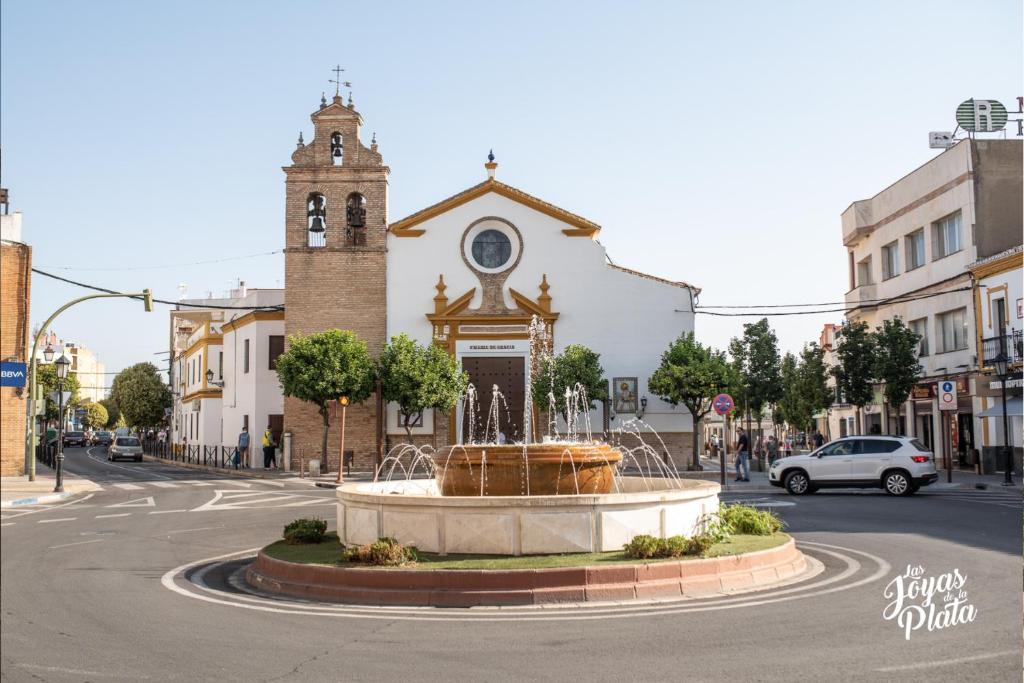 une église avec une fontaine au milieu d'une rue dans l'établissement Sevilla Apartamento en Camas a minutos del centro de Sevilla Wifi, à Camas