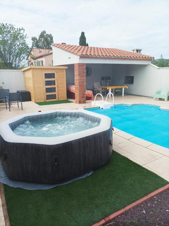 - un grand bain à remous dans une cour à côté d'une piscine dans l'établissement La Céret'nitude, à Céret