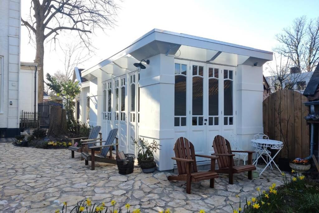 a small shed with chairs and a table in a yard at Oranjerie, 7 km onder Groningen in Paterswolde