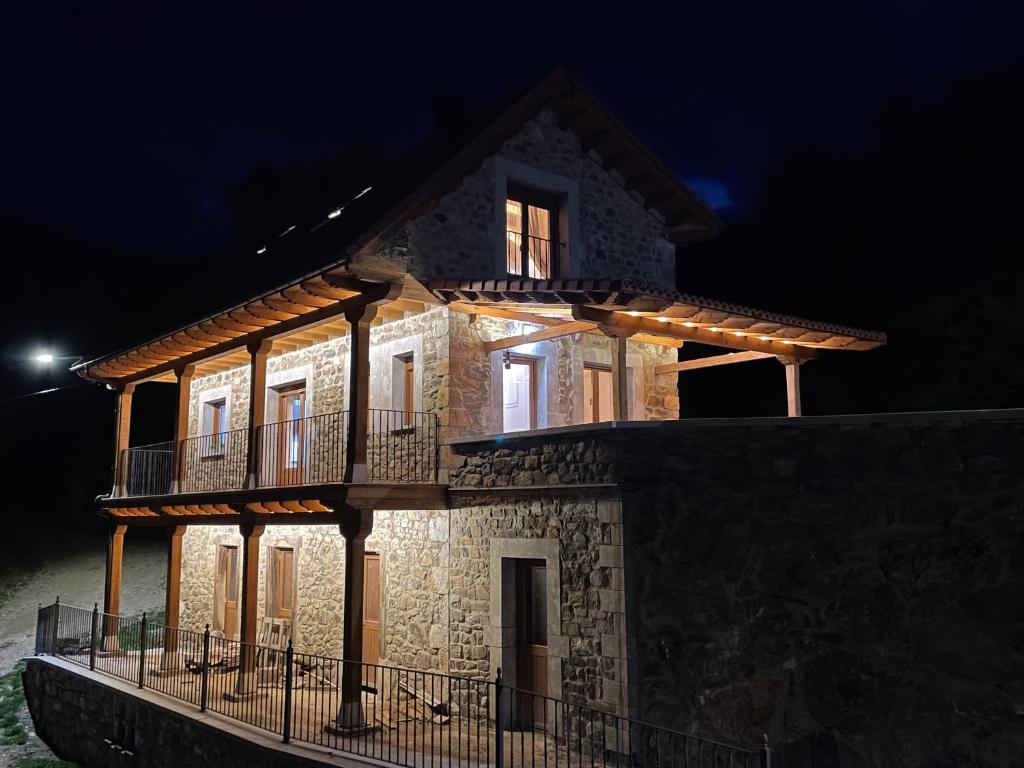 a stone house with a balcony on top of it at Los Toriles in Los Espejos de la Reina