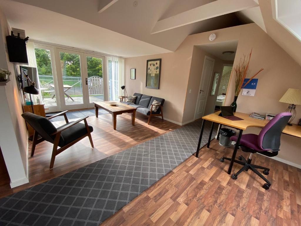 un soggiorno a pianta aperta con scrivania e sedie di Country flat a Roskilde