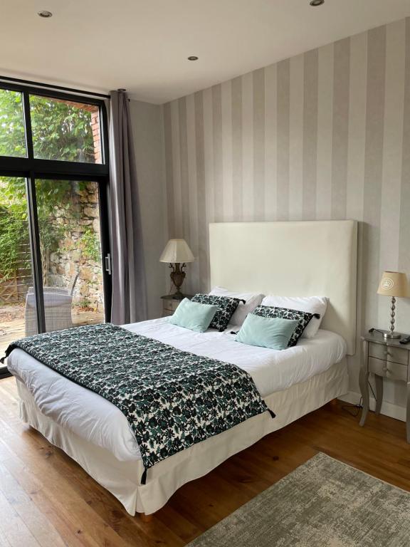 a bedroom with a large bed and a large window at Maison La Tour in Dinan