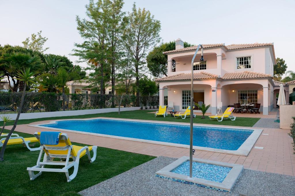 a villa with a swimming pool and a house at Villa Wilker in Vilamoura