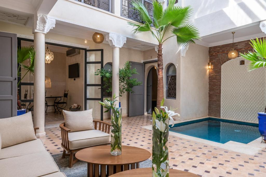 a villa with a swimming pool and a living room at Riad Beldi in Marrakesh