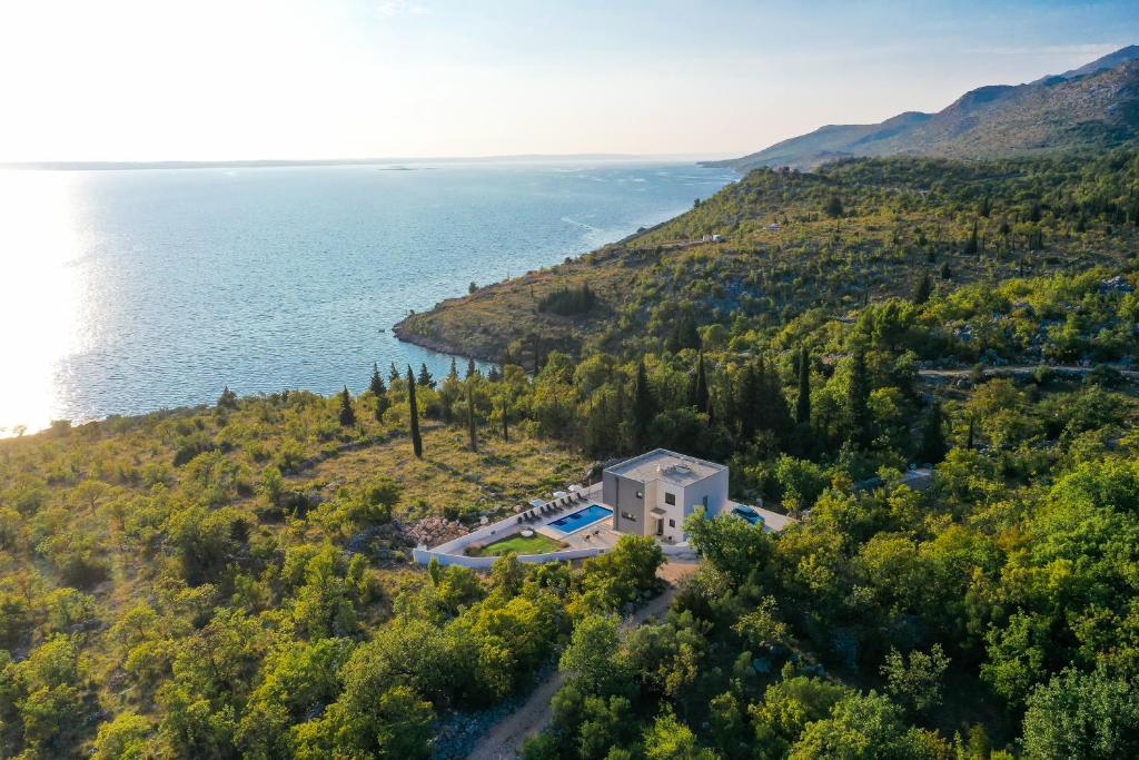 z góry widok na dom na wzgórzu nad wodą w obiekcie Royal Promons - heated pool w mieście Starigrad-Paklenica